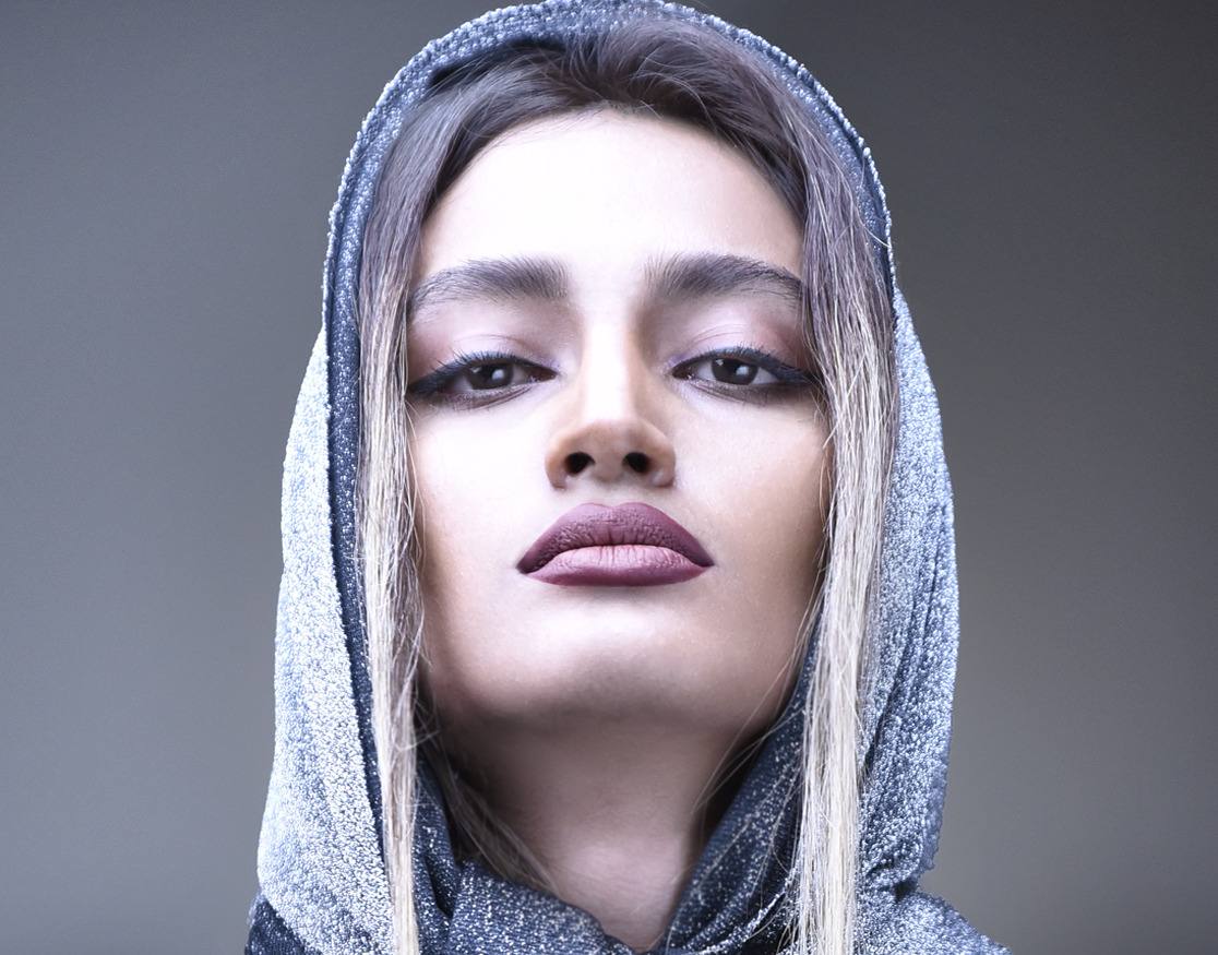 صورة جمالية لامرأة ترتدي غطاء رأس فضيًا محبوكًا