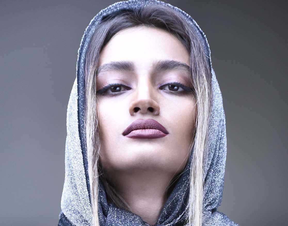 Beauty portrait of a woman in a silver knitted hood