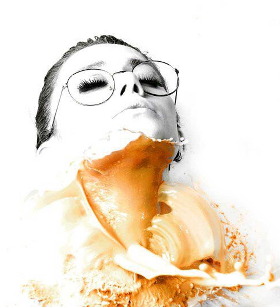 A woman in glasses with her eyes closed, in a splash of orange paint