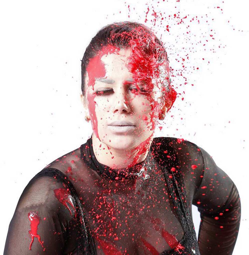 A woman caught in a burst of red paint